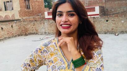 Sunita, ausgebildete Krankenschwester aus Kathmandu, lächelt in die Kamera.